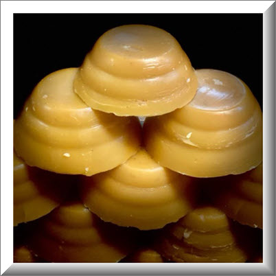 Natural bees wax poured into small round disks for consumer sale delivery available in Saskatoon